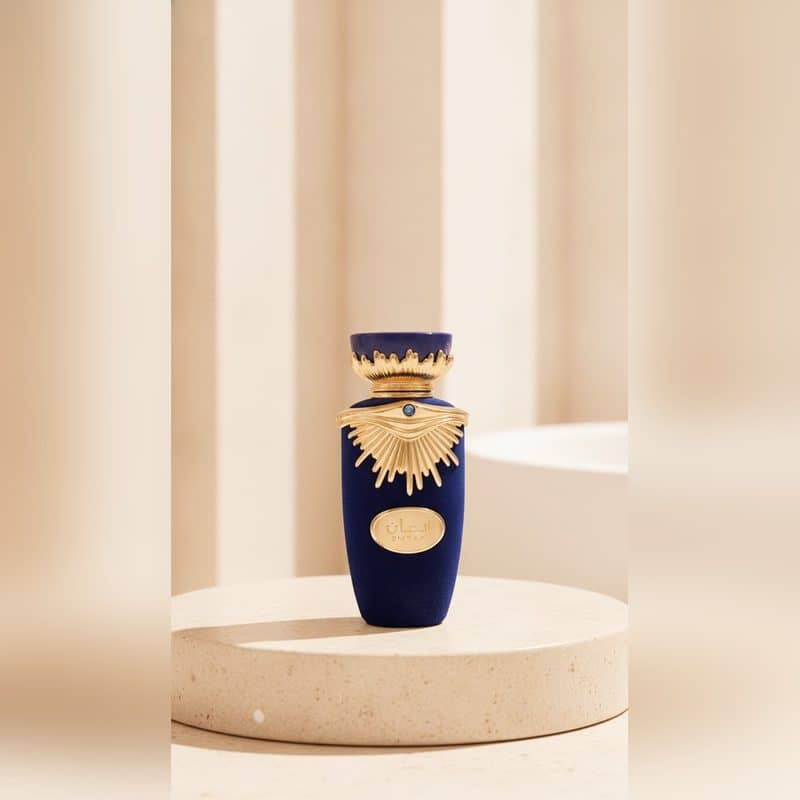 Perfume en frasco azul y dorado sobre un podio, foto de producto generada por Golden Ratio